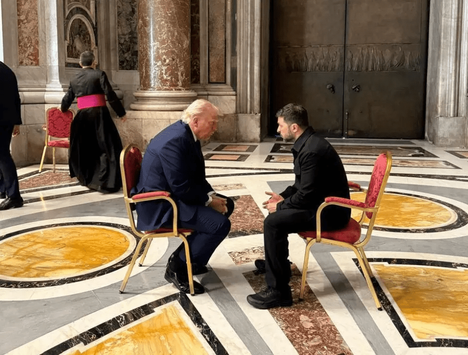 Donald Trump and another man seated in chairs.