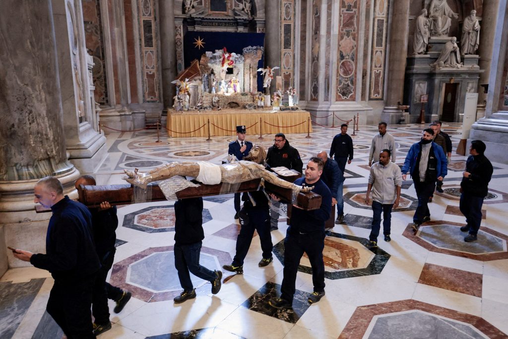 Workers carry a crucifix inside the Saint Peter's Basilica at the Vatican