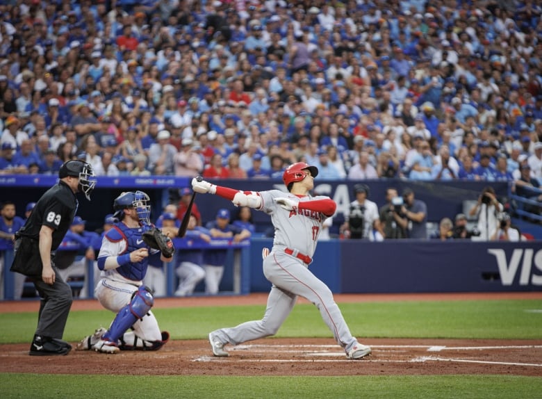 A baseball player swings his bat.