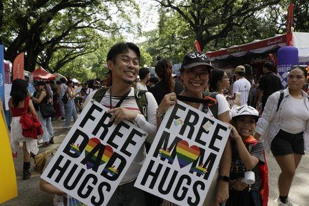 Parents giving out hugs at Pride teach son importance of accepting others