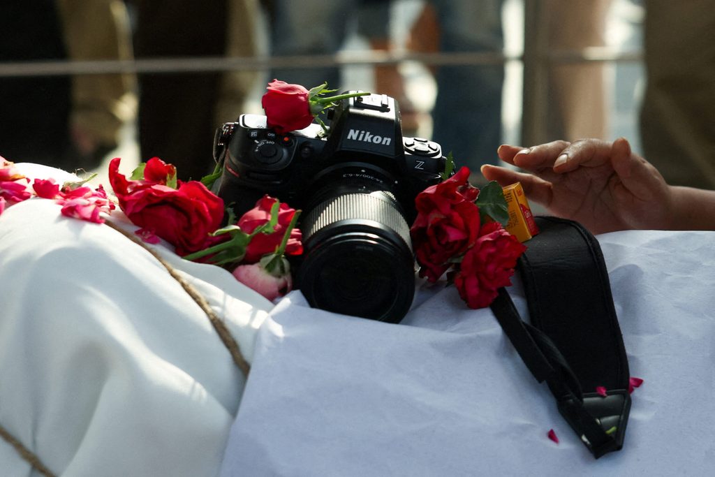 A digital camera is placed on the body of photographer Raghu Rai during his funeral in New Delhi