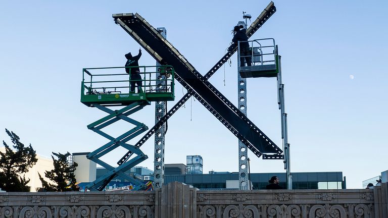 Workers install lighting on an "X" sign atop the downtown San Francisco building that housed what was formally known as Twitter, now rebranded X by owner Elon Musk, Friday, July 28, 2023. (AP Photo/Noah Berger)