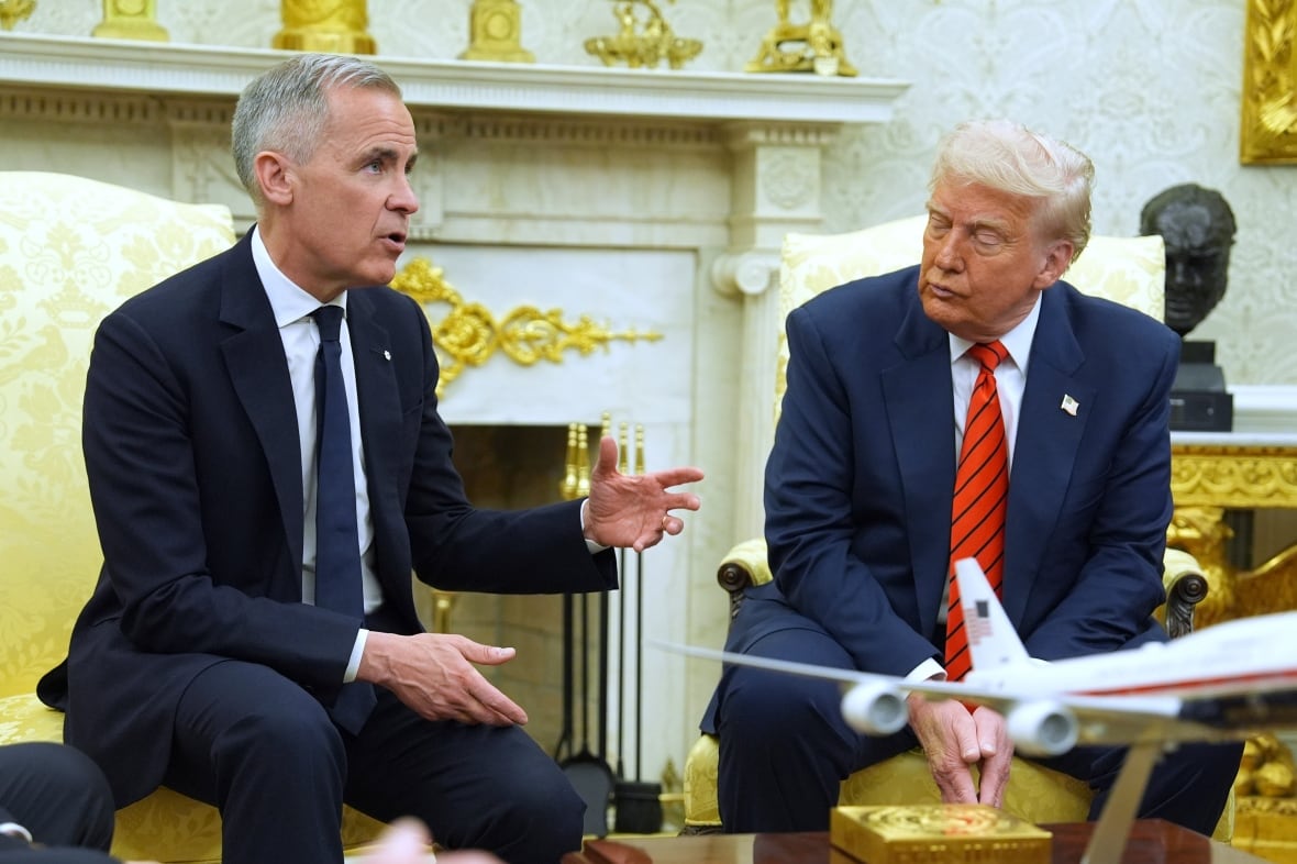 Two men sit in an ornate room.