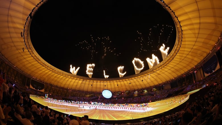 Fireworks display the word 'welcome' above a stadium.