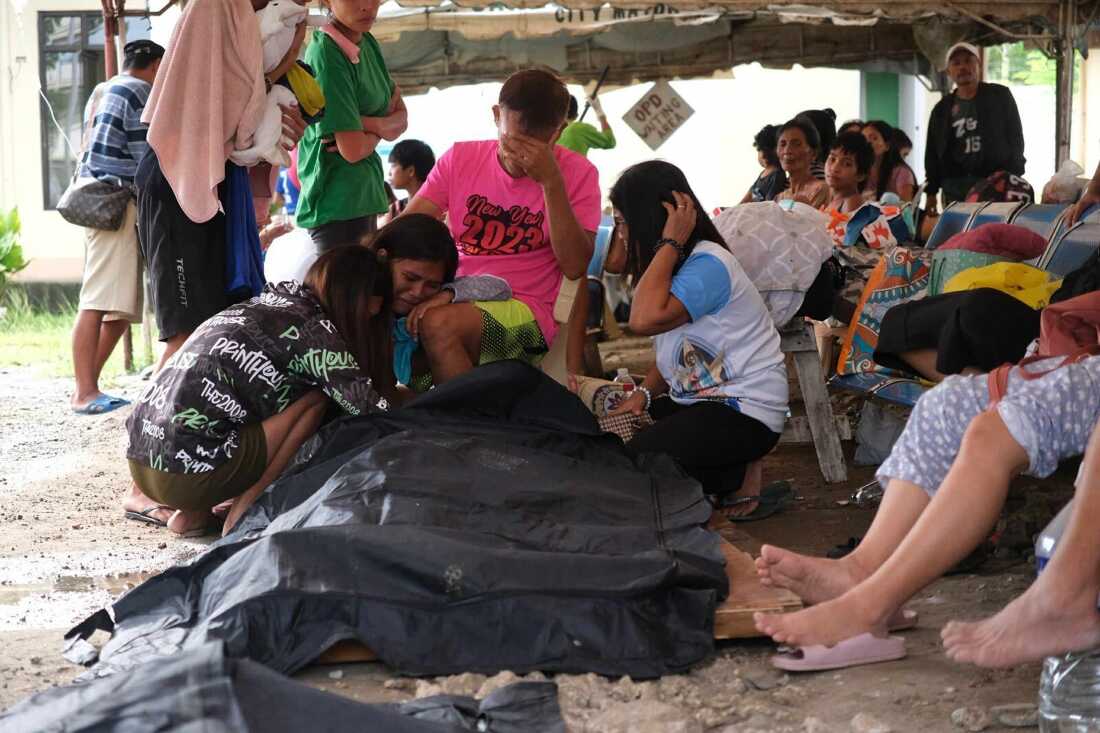 People surround a body bag in Bogo City, Cebu province, Philippines Wednesday, Oct. 1, 2025 after an offshore earthquake on late Tuesday.