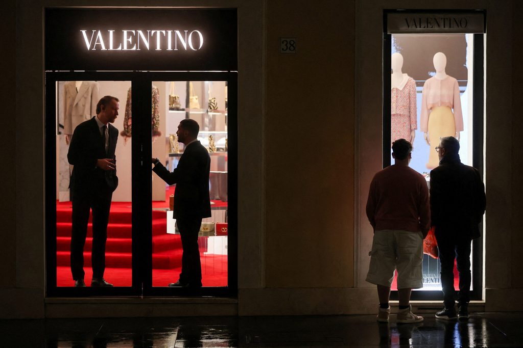 Workers talk inside a Valentino boutique after Italian fashion designer Valentino Garavani died, in Rome