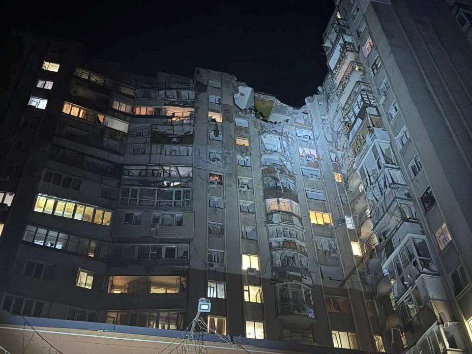 Damaged apartment building at night after a drone strike.