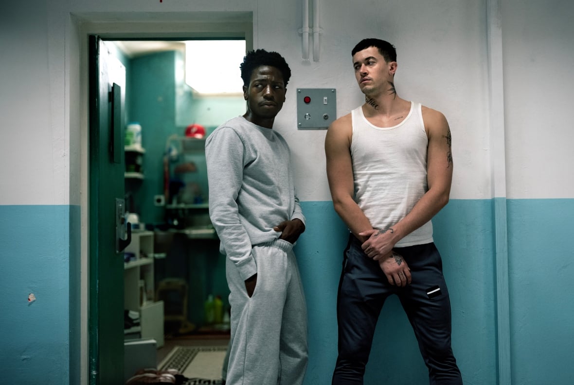 Two men stand inside of a prison.